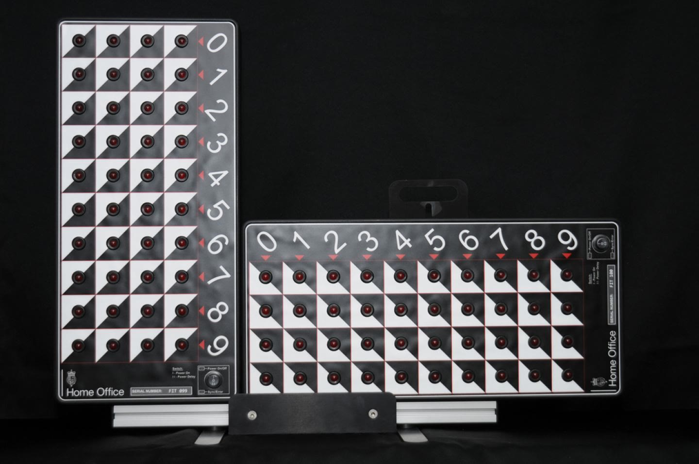 A pair of Home Office FIT boards on a stand: one upright with the digits 0 to 9 running down beside four columns of red lights, one on its side with the digits running across above four rows